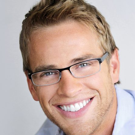 Young handsome man with great smile wearing fashion eyeglasses against neutral background with lots of copy space